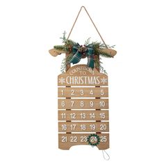 a wooden calendar hanging on a wall with christmas decorations and evergreens around the clock