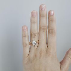 a woman's hand with a ring on it and a diamond in the middle