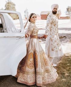 a man and woman standing next to a white car