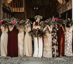 a group of women standing next to each other holding bouquets in their hands and smiling at the camera