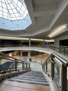 an escalator in a large building with skylights