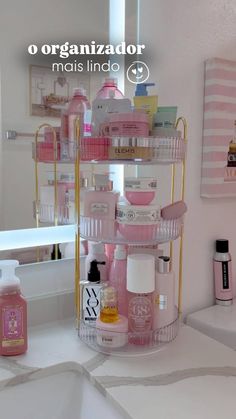 a bathroom with pink and gold accessories on the counter top, including soaps, shampoos, and lotion bottles