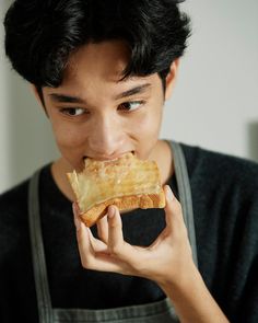 a young man eating a piece of bread