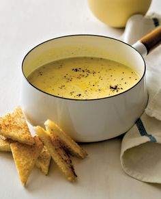 a white bowl filled with soup next to crackers