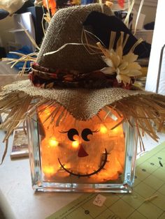 a lighted pumpkin in a scarecrow hat