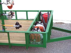 a green trailer with tools in the back