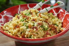 a red bowl filled with macaroni and peas