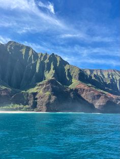 the mountains are covered in green grass and blue water