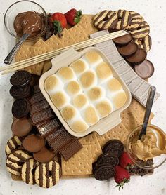 an assortment of desserts on a platter with strawberries and chocolate