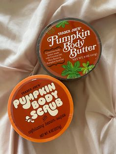 two tins of pumpkin body butter on a white sheet