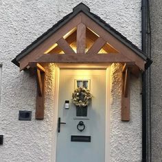 a white front door with a wreath on the top and lights above it that are lit up