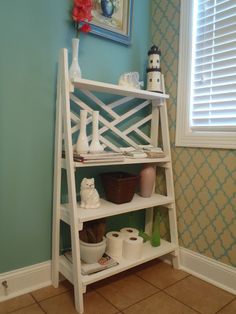 a shelf with toilet paper and other items on it in the corner of a room