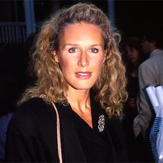 a woman with blonde hair and blue eyes is posing for the camera at an event