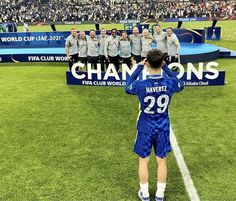 the soccer team is standing on the field with their arms in the air as they sing