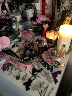 a table topped with lots of jewelry and candles