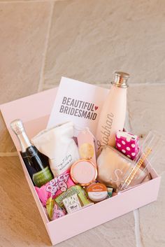 a pink box filled with lots of different types of personal care items on a tile floor