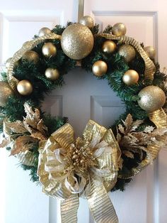 a christmas wreath with gold and silver ornaments hanging on the front door to give it a festive feel