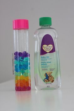 two plastic bottles with different colored beads in them next to each other on a white surface