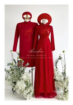 two red gowns on display in front of white flowers