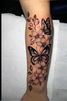 a woman's leg with butterflies and flowers tattoo on the side of her arm