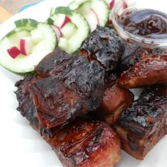 barbecue ribs and cucumbers on a white plate