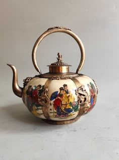 an ornate teapot with painted scenes on it