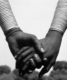 two people holding hands while standing next to each other