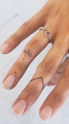 a woman's hand with a small tattoo on the middle finger and an arrow in the middle