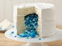 a cake with white frosting and blue sprinkles is shown on a plate