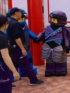 some people are dressed up as ninjas and one is holding the hand of another person