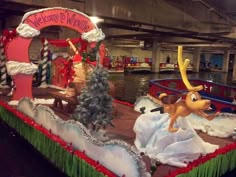 there is a float decorated with christmas decorations and reindeers on the boat in the water