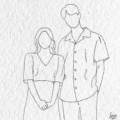 a man and woman standing next to each other in front of a piece of paper