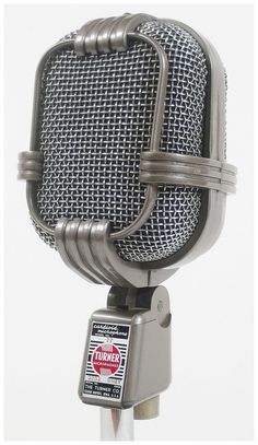 an old fashioned microphone on a stand with a sticker attached to the front end