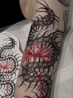 a woman's leg with tattoos on it and a red flower in the center