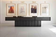 an office lobby with three framed pictures on the wall and a reception desk in front of it