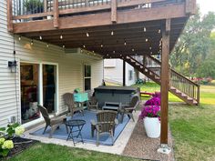 an outdoor patio with furniture and lights on the outside wall, next to a deck