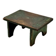 an old wooden table with green paint on it