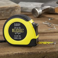 a yellow and black measuring tape on top of a wooden table