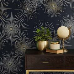 a table with a potted plant on top of it next to a wallpaper