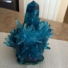 a blue piece of glass sitting on top of a white tablecloth covered countertop