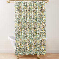 a shower curtain with yellow and green leaves on it