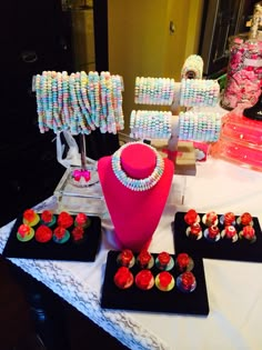 an assortment of colorful candy on display at a party or event with pink, white and blue decorations