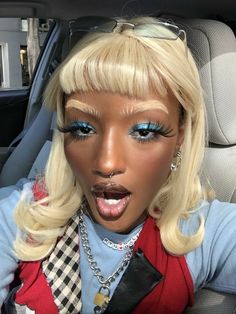 a barbie doll sticking her tongue out in the back seat of a car with blue eyes and blonde hair