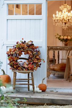 a wooden chair sitting in front of a door with a wreath on top of it