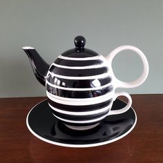 a black and white striped tea pot on a saucer