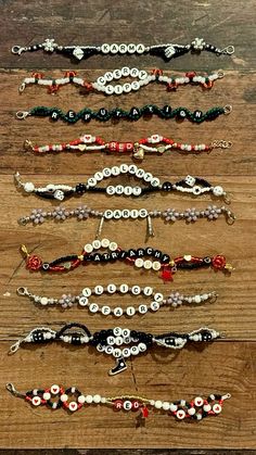 several bracelets are lined up on a wooden surface, each with different designs and colors