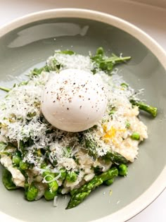 a plate with asparagus, rice and an poached egg on top