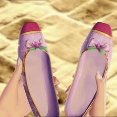 a pair of purple shoes being held by someone's hand