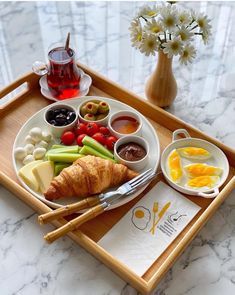 a breakfast tray with croissants, fruit and vegetables