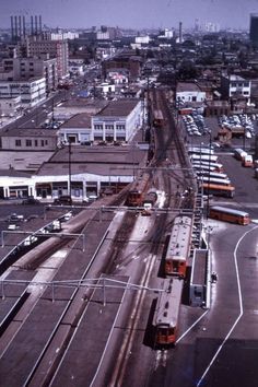 an aerial view of a train yard with trains on the tracks and buildings in the background